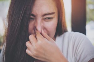 woman holding her nose