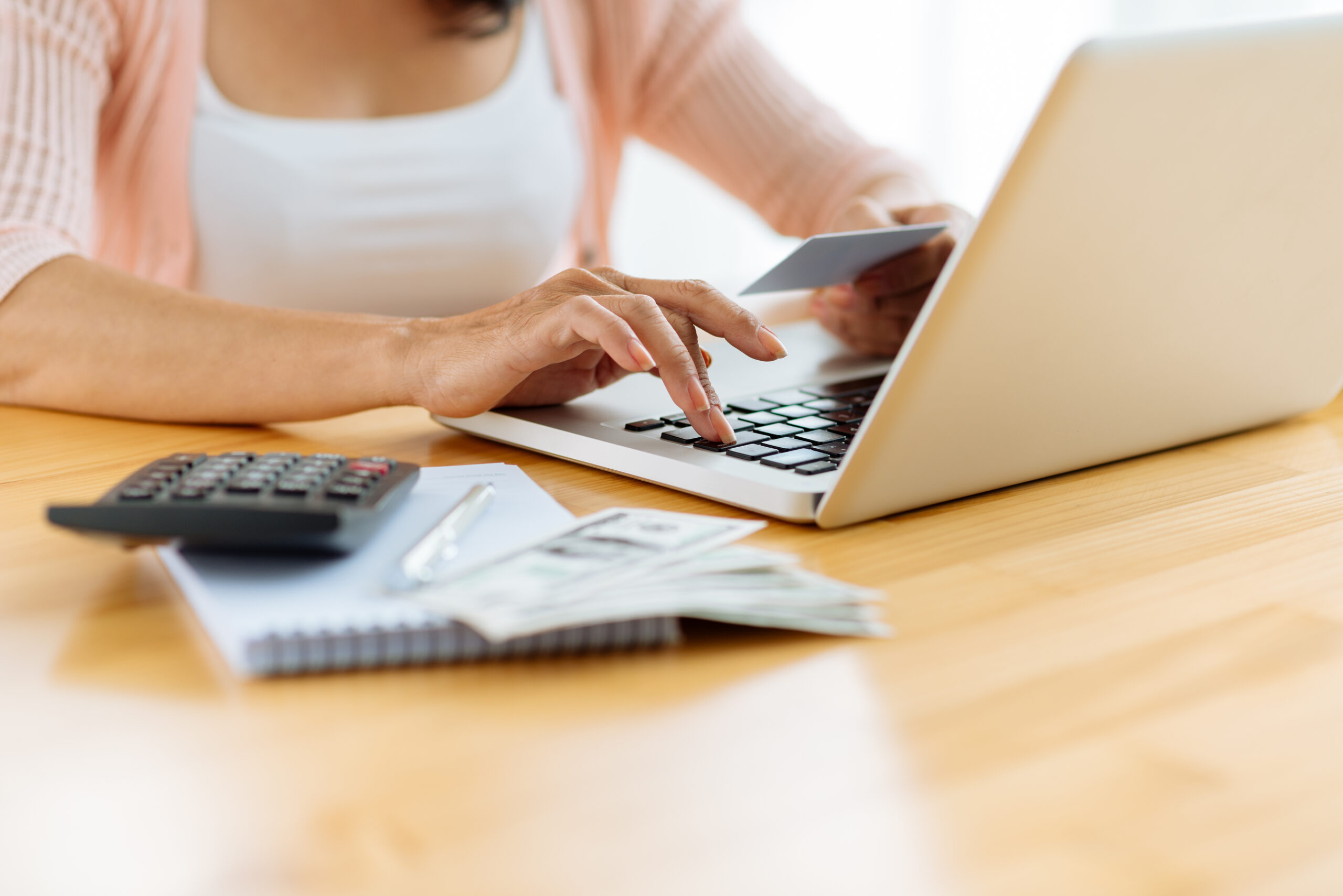 woman typing information from a business card on a laptop