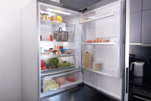 open refrigerator willed with mostly fresh vegetables and fruit