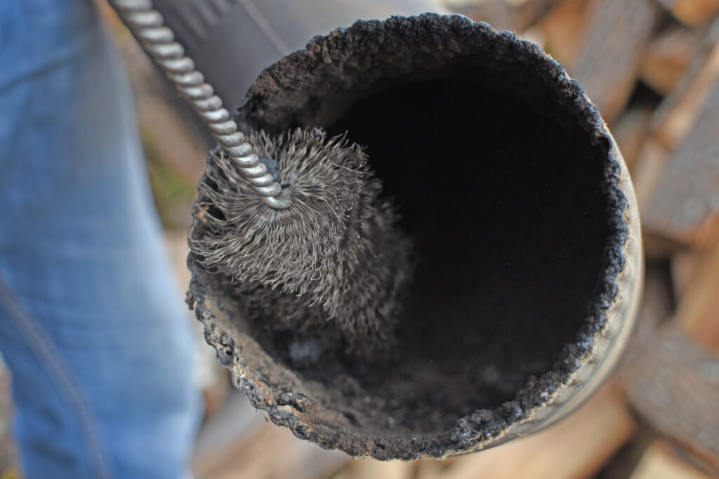 person cleaning a chimney pipe