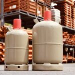 2 large metal containers with Refrigerant in front of racks of large metal cylinder tubing