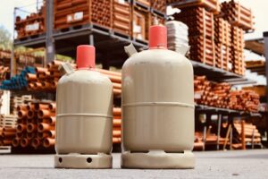 2 large metal containers with Refrigerant in front of racks of large metal cylinder tubing